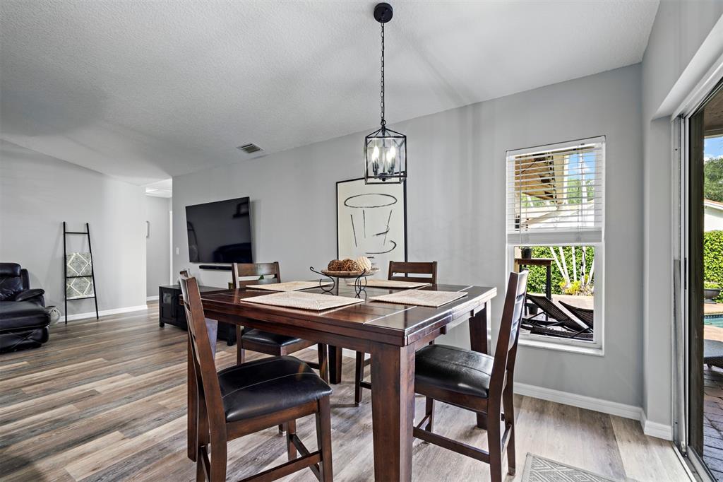 5133 Northwest 47th Avenue Coconut Creek, FL 33073 - Photo 13 of 44 a view of a dining room with furniture window and wooden floor