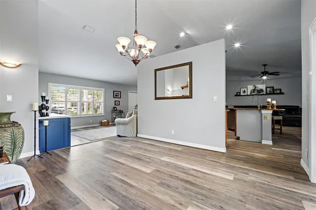 a view of a livingroom with a furniture wooden floor and chandelier