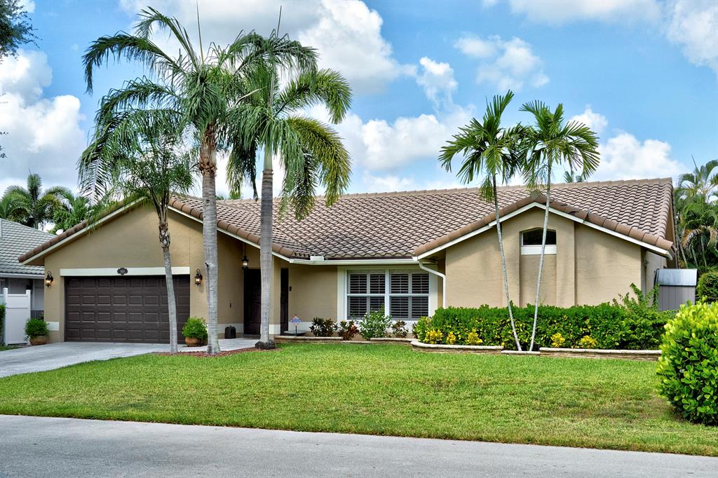 5133 Northwest 47th Avenue Coconut Creek, FL 33073 - Photo 2 of 44 a front view of house with yard and green space