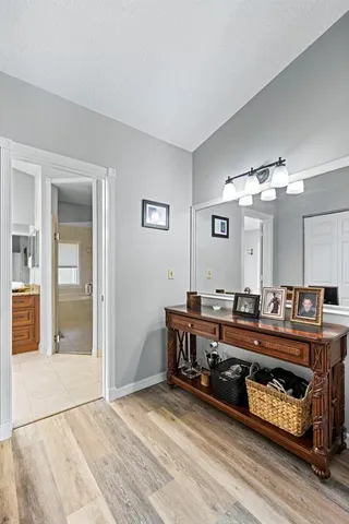 a spacious bathroom with a granite countertop sink a mirror and a bathtub