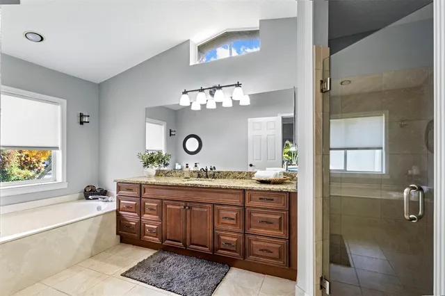 a bathroom with a granite countertop sink mirror and shower