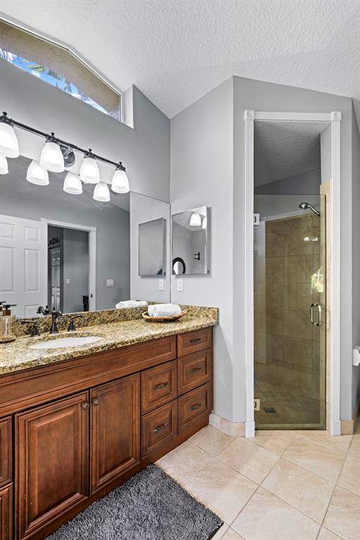 5133 Northwest 47th Avenue Coconut Creek, FL 33073 - Photo 25 of 44 a bathroom with a granite countertop sink mirror and shower