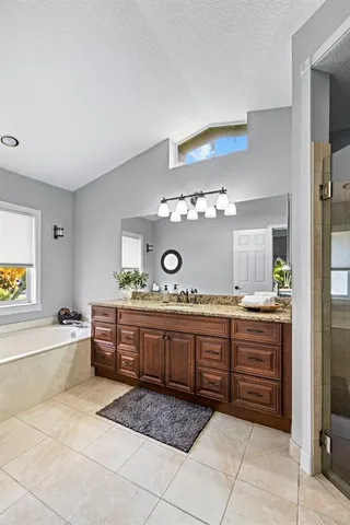 a bathroom with a tub sink and mirror