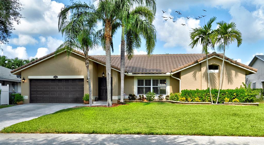 5133 Northwest 47th Avenue Coconut Creek, FL 33073 - Photo 39 of 44 a front view of house with yard and green space