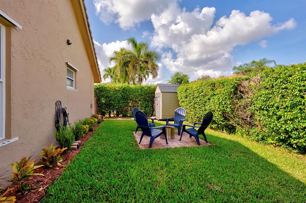 5133 Northwest 47th Avenue Coconut Creek, FL 33073 - Photo 40 of 44 a view of a backyard with table and chairs and potted plants