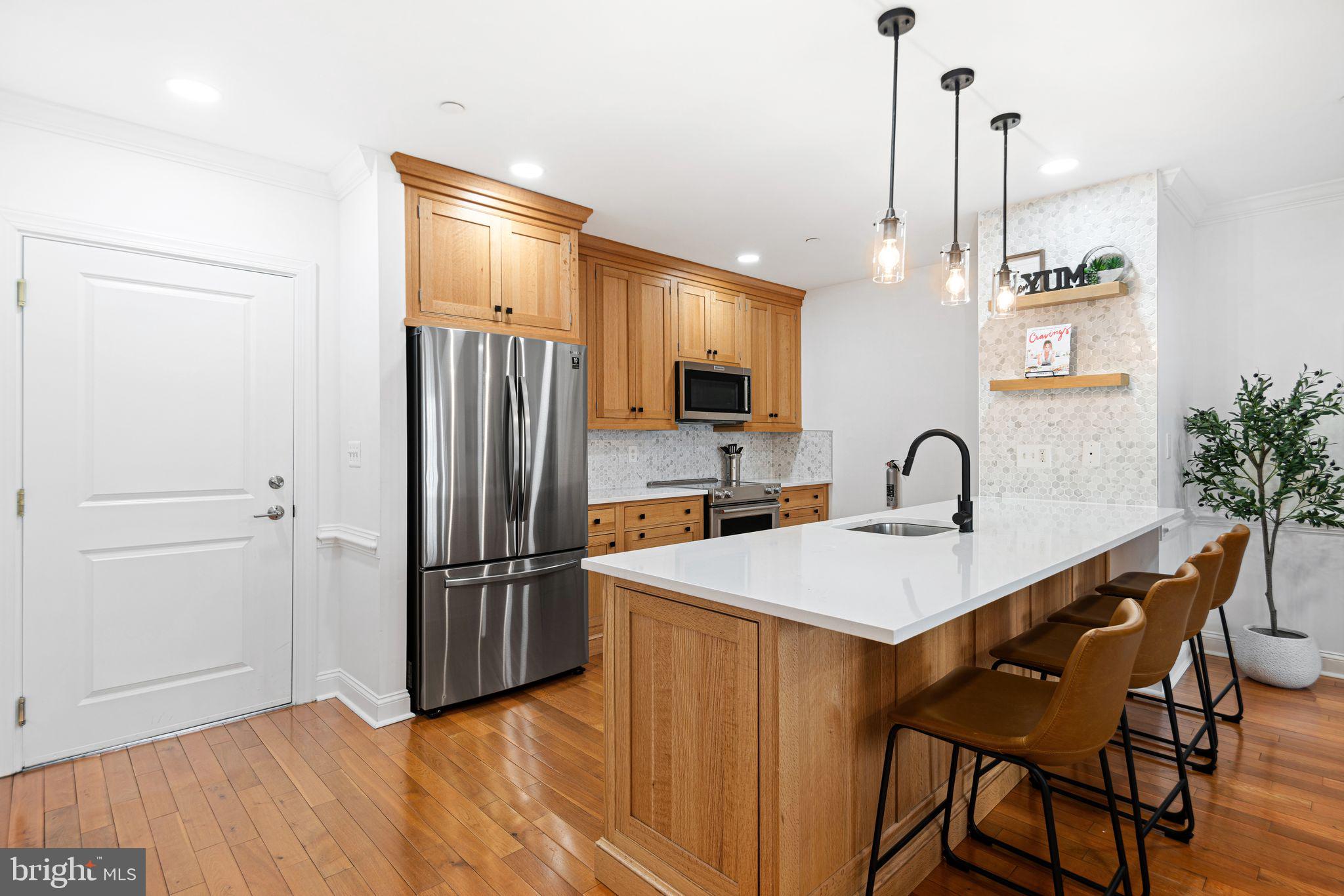 30 Kings Court, Unit 307 Haddonfield, NJ 08033 - Photo 3 of 15 a kitchen with stainless steel appliances granite countertop a refrigerator a sink a stove and a wooden floors
