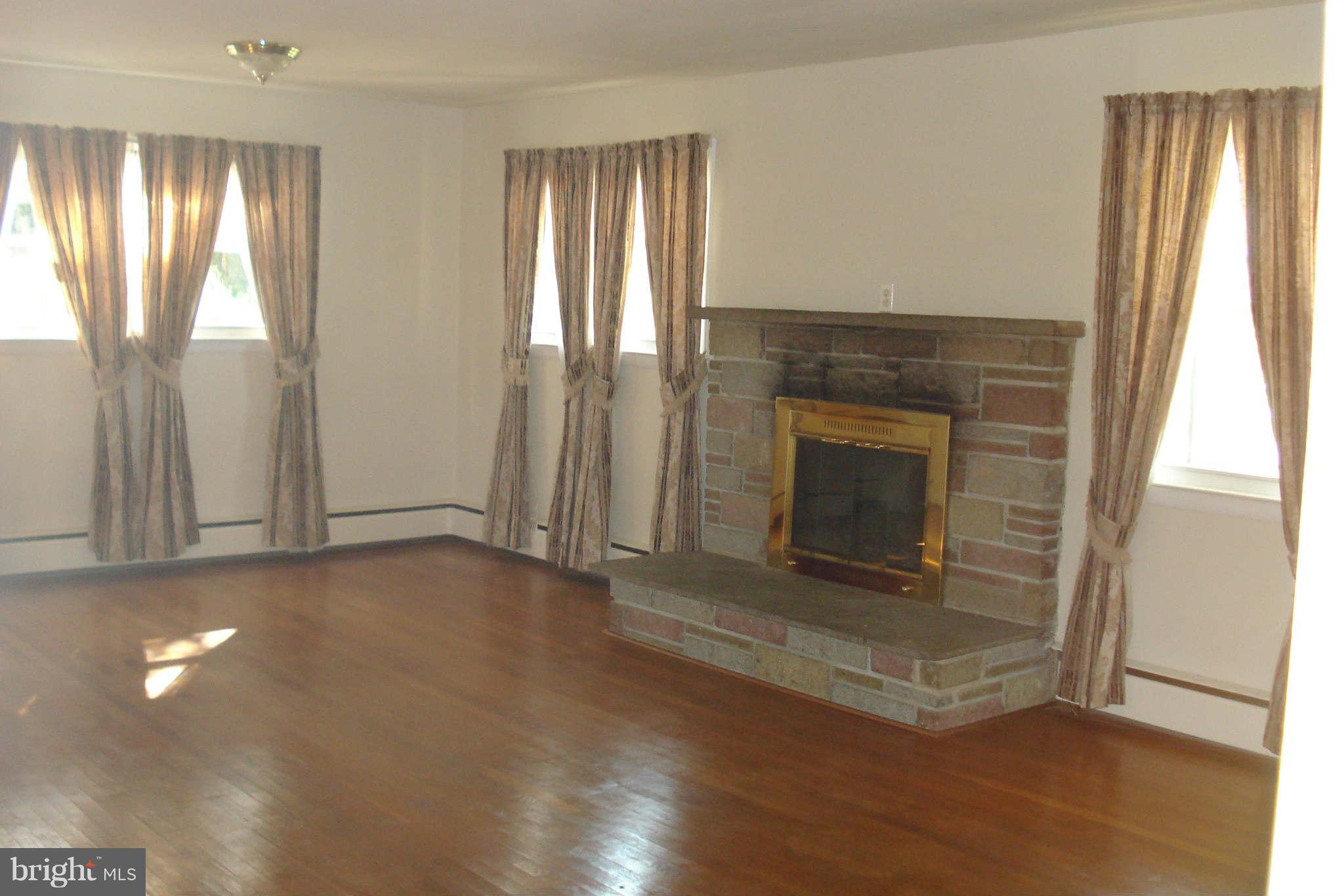 15725 Barnesville Road Boyds, MD 20841 - Photo 8 of 11 an empty room with wooden floor fireplace and windows