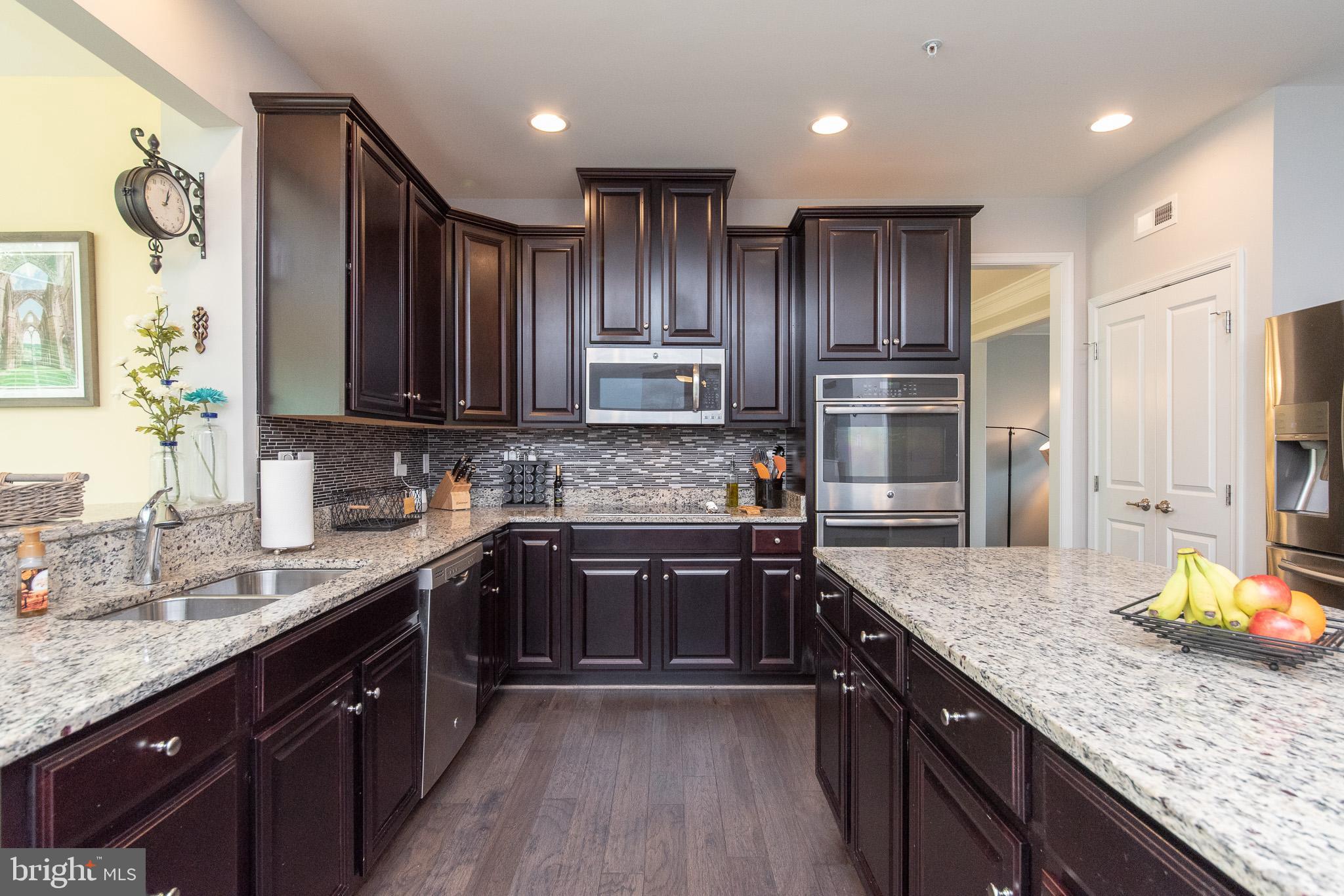 10426 Windlass Run Road Baltimore, MD 21220 - Photo 13 of 56 a kitchen with kitchen island granite countertop wooden cabinets stainless steel appliances a sink and a center island