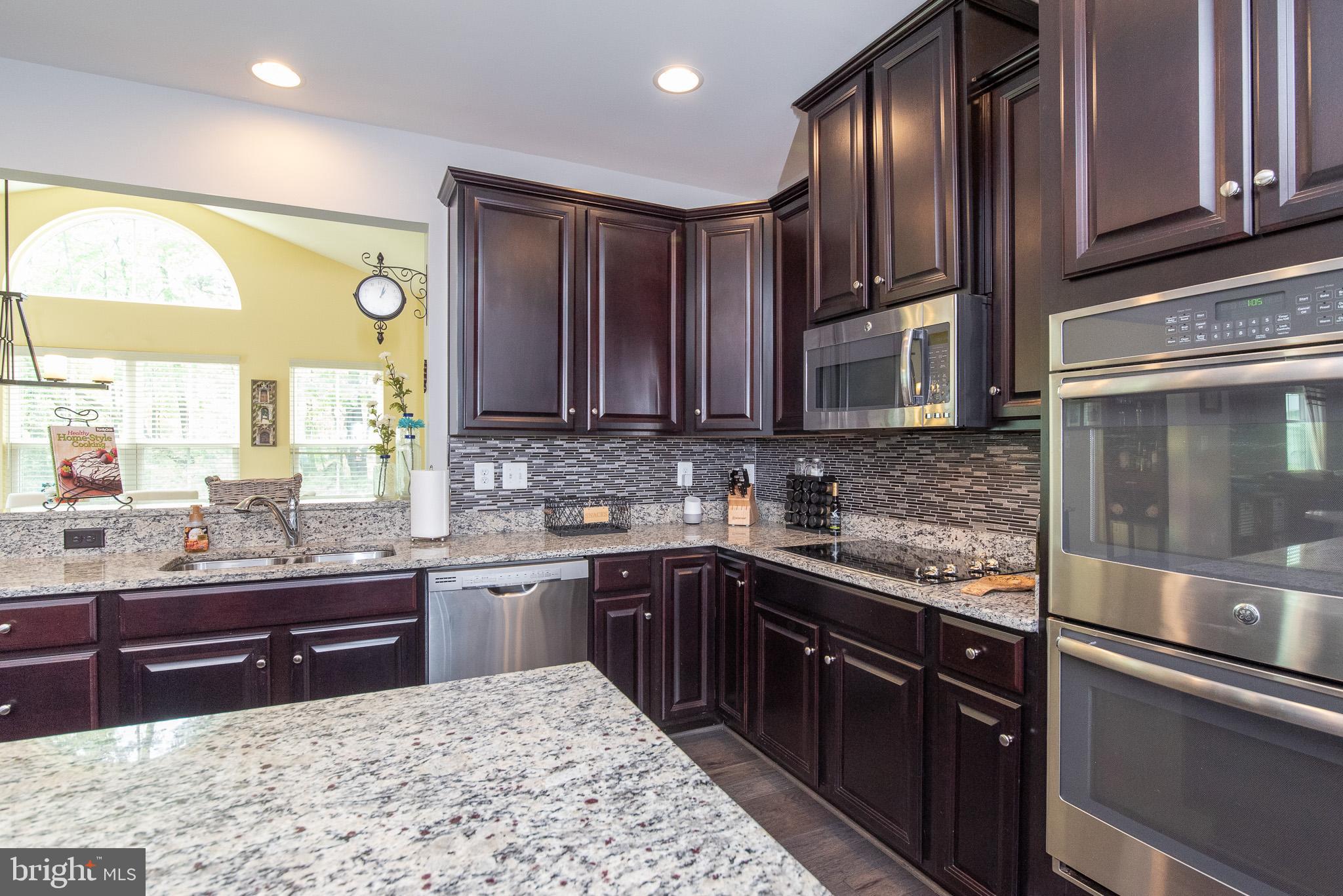 10426 Windlass Run Road Baltimore, MD 21220 - Photo 15 of 56 a kitchen with stainless steel appliances granite countertop wooden cabinets a sink and dishwasher