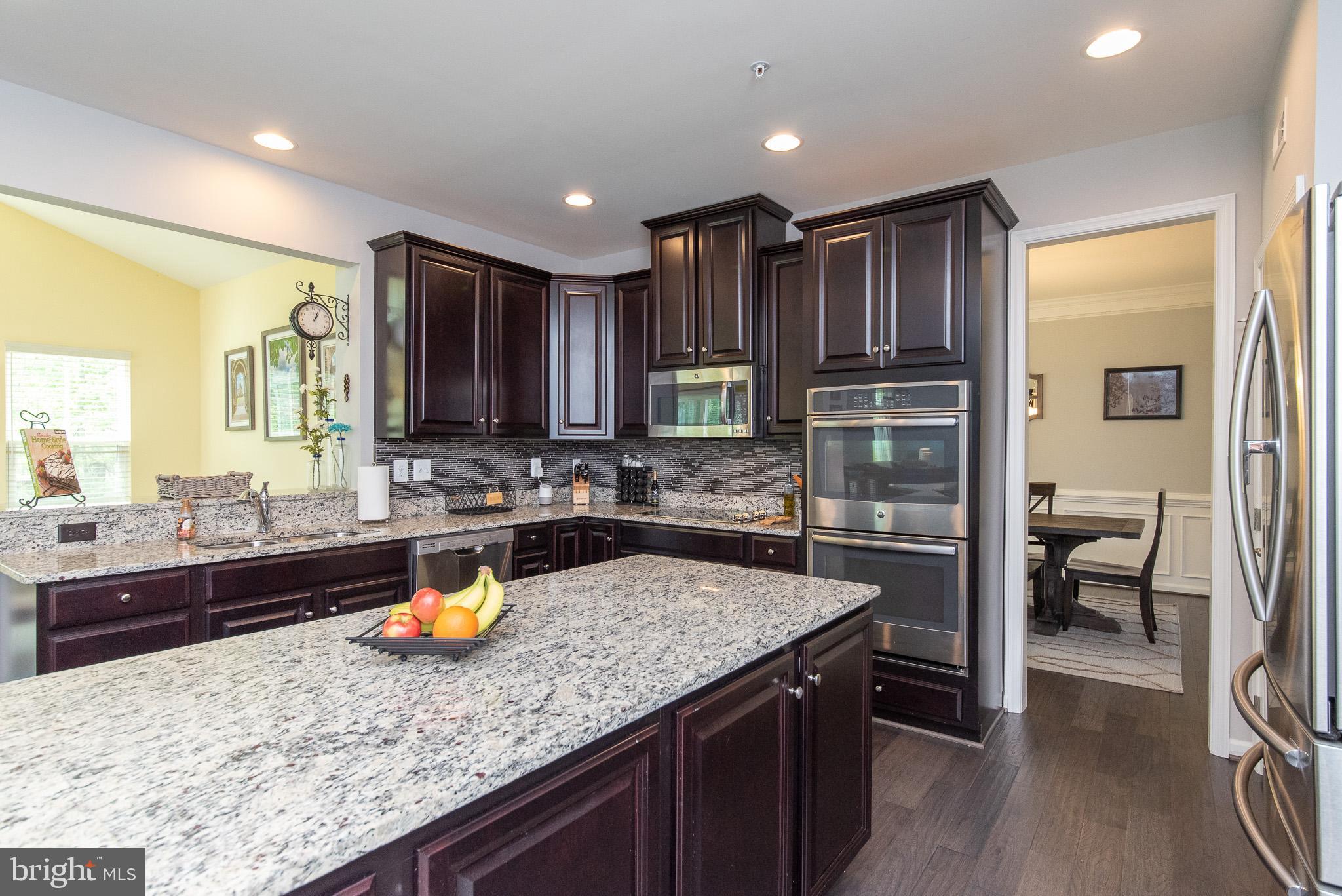 10426 Windlass Run Road Baltimore, MD 21220 - Photo 16 of 56 a kitchen with a sink a stove and chairs