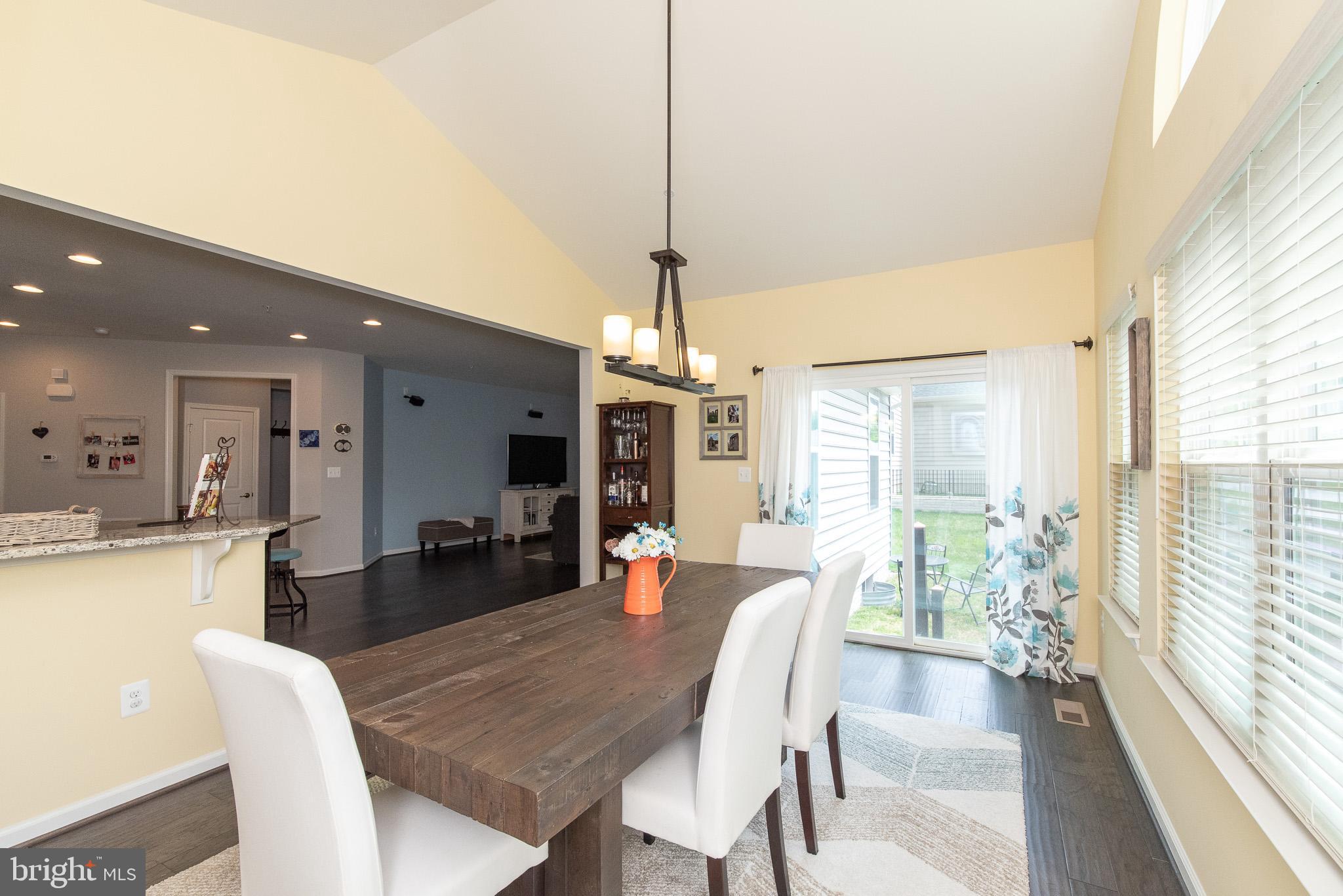 10426 Windlass Run Road Baltimore, MD 21220 - Photo 18 of 56 a view of a dining room and livingroom with furniture wooden floor a chandelier