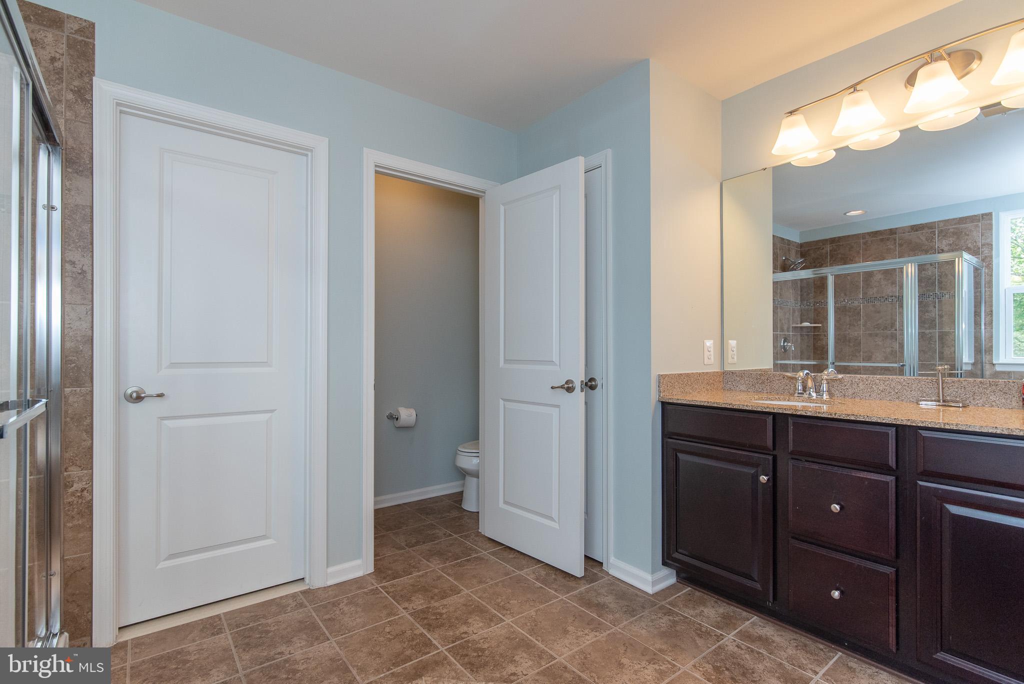 10426 Windlass Run Road Baltimore, MD 21220 - Photo 35 of 56 a spacious bathroom with a double vanity sink and a mirror