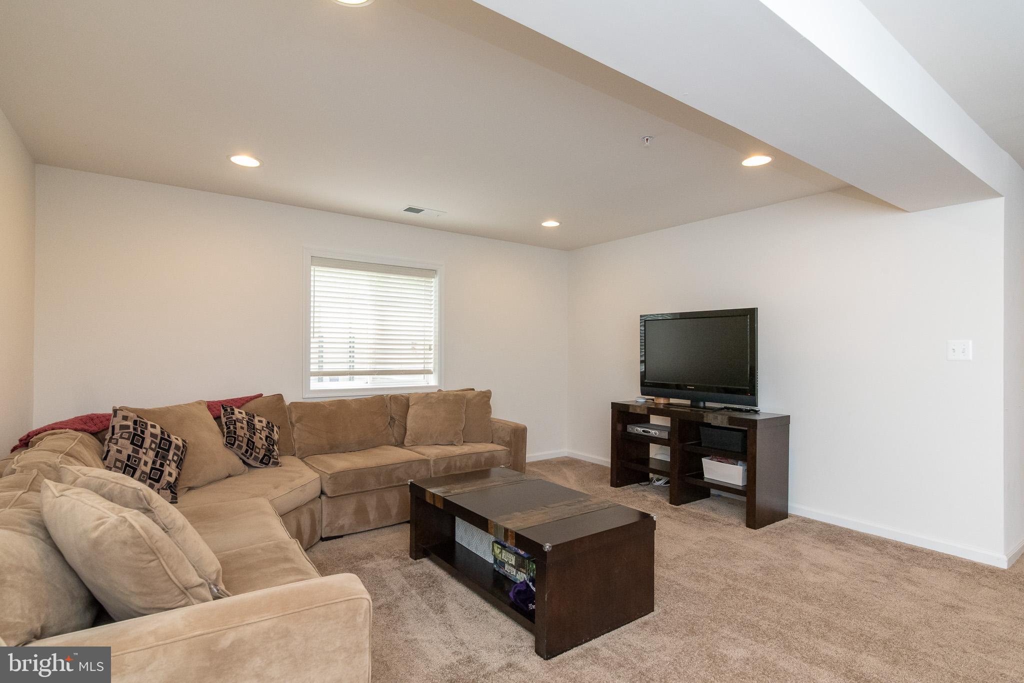 10426 Windlass Run Road Baltimore, MD 21220 - Photo 46 of 56 a living room with furniture and a flat screen tv