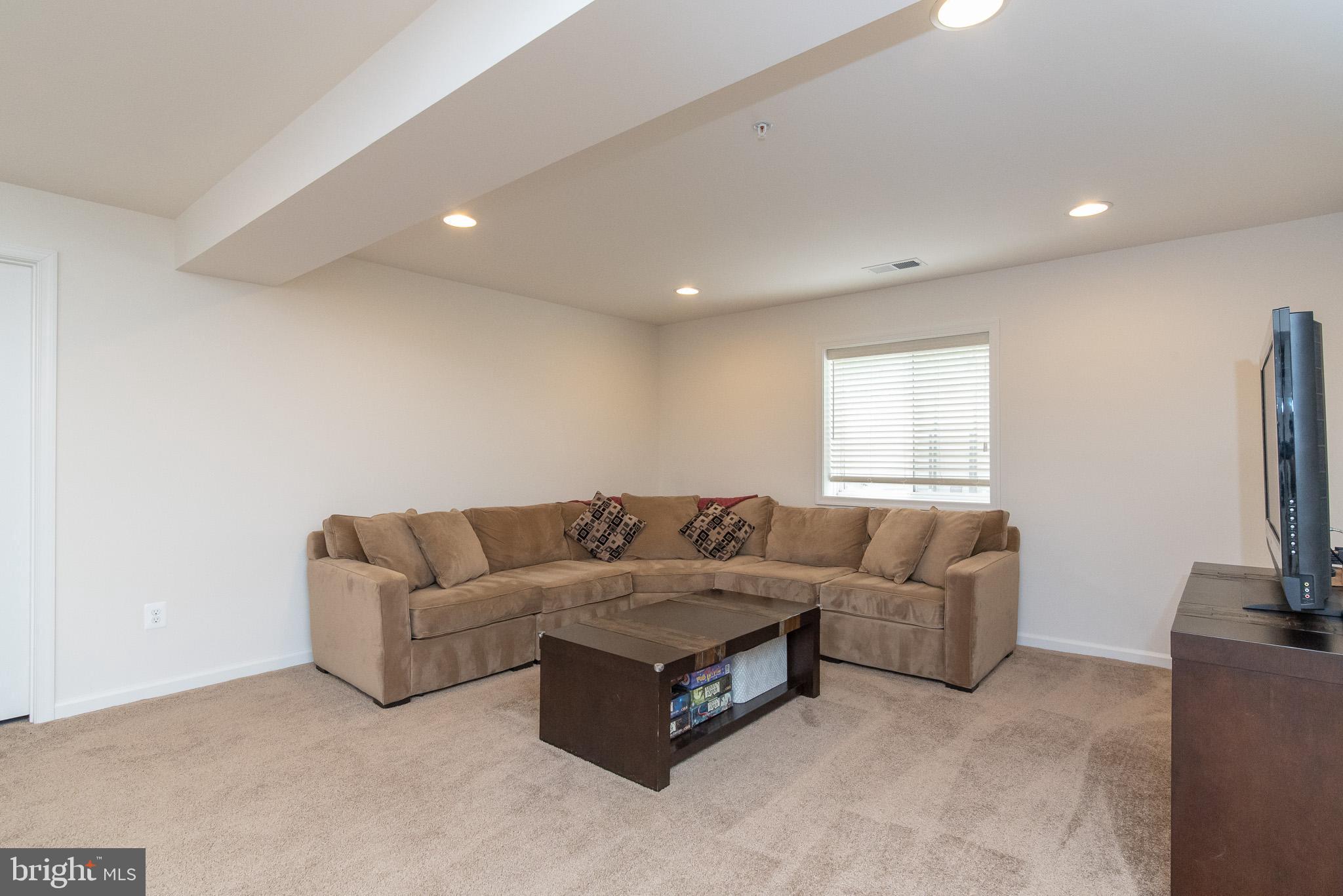 10426 Windlass Run Road Baltimore, MD 21220 - Photo 48 of 56 a living room with couches and a flat screen tv