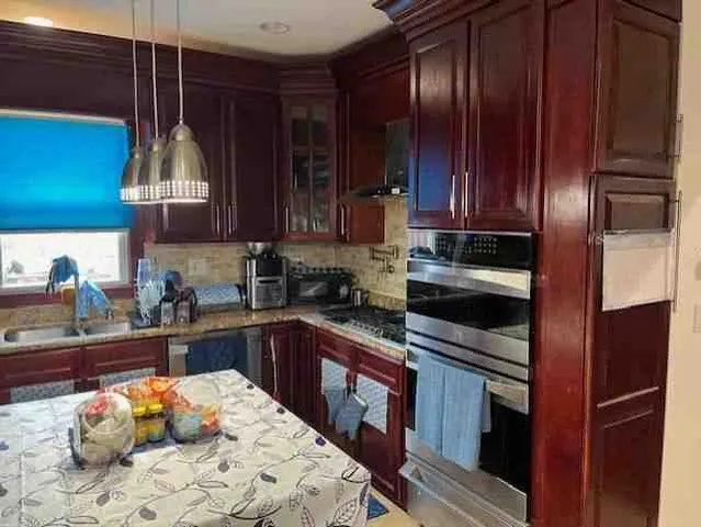 a kitchen with stainless steel appliances granite countertop wooden cabinets sink and stove