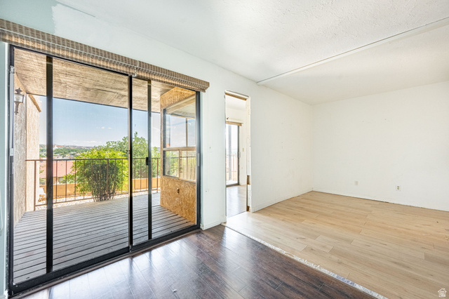 161 West 950 South, Unit C5 St. George, UT 84770 - Photo 5 of 14 Spacious room with sliding glass doors opening to an outdoor deck featuring an iron railing