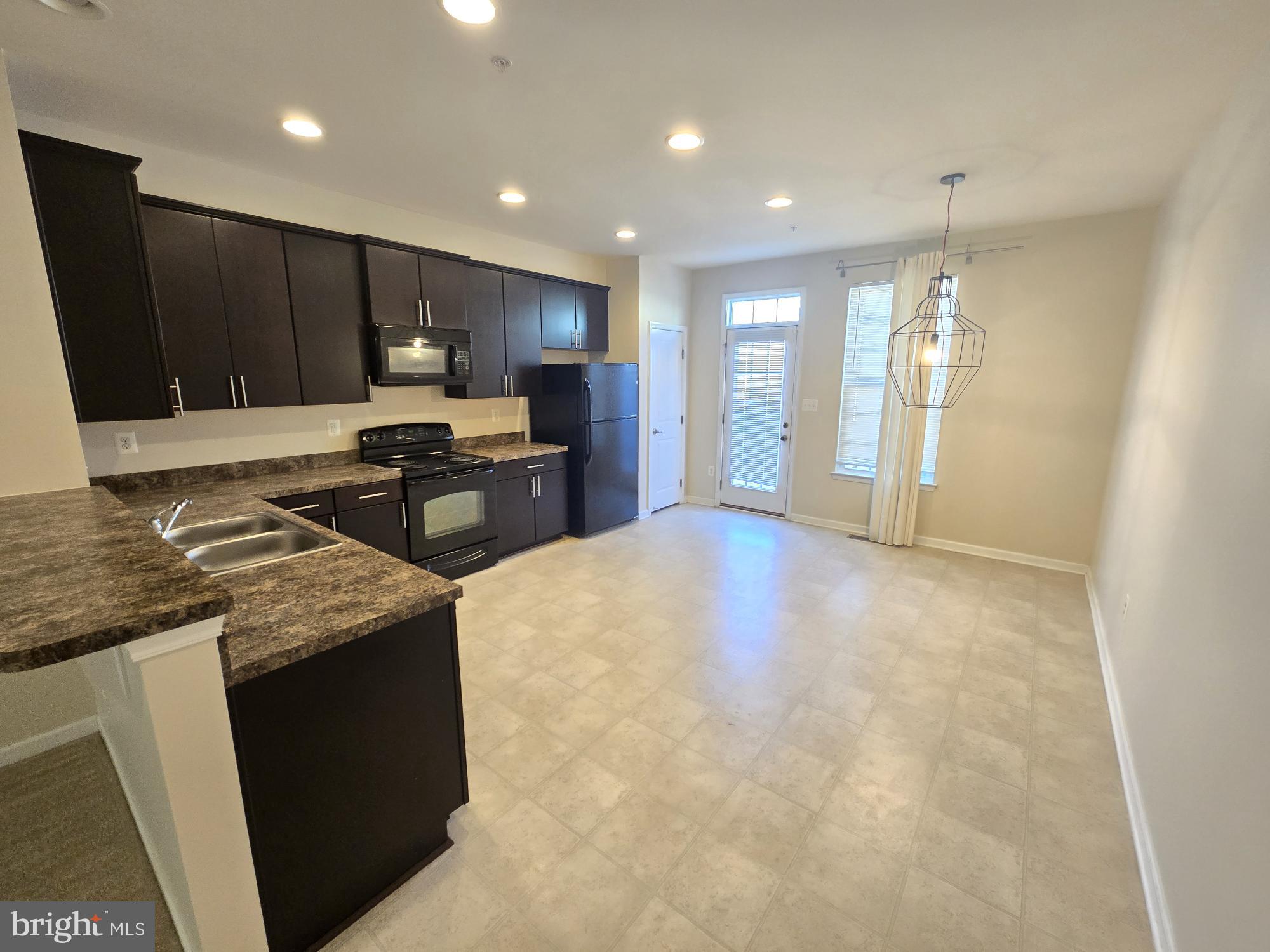 705 South Macon Street Baltimore, MD 21224 - Photo 6 of 29 a large kitchen with stainless steel appliances granite countertop a stove a sink a refrigerator and a microwave