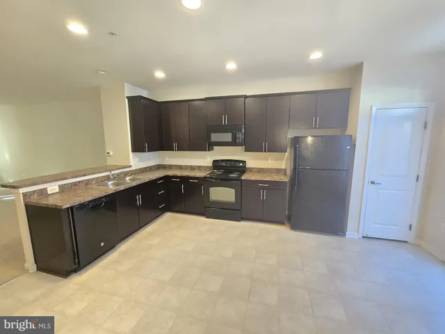 a kitchen with a stove a sink and a refrigerator
