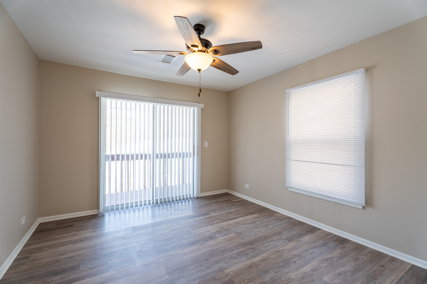 774 Terrace Court, Unit T Elgin, IL 60120 - Photo 15 of 27 an empty room with wooden floor fan and windows