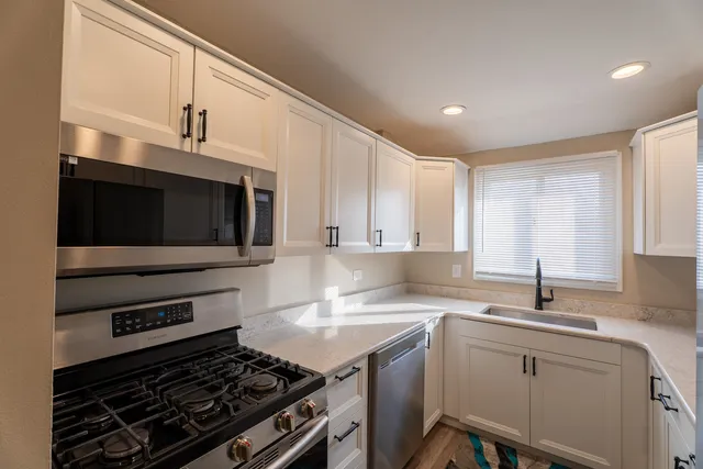a kitchen with a stove a sink and a microwave