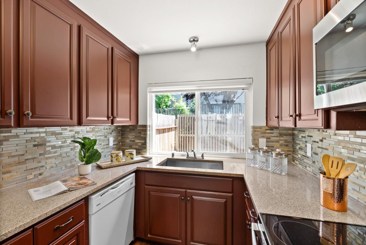 22812 Longdown Road Cupertino, CA 95014 - Photo 12 of 45 a kitchen with stainless steel appliances granite countertop a sink a stove cabinets counter space and a window