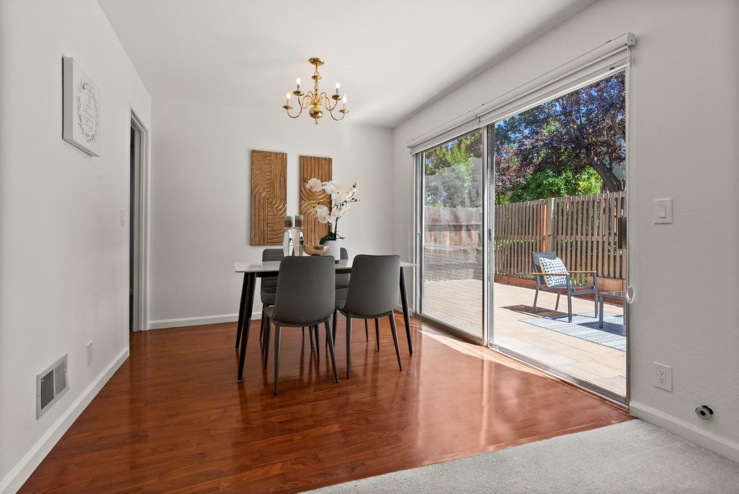 22812 Longdown Road Cupertino, CA 95014 - Photo 16 of 45 a dining room with wooden floor a glass table and chairs