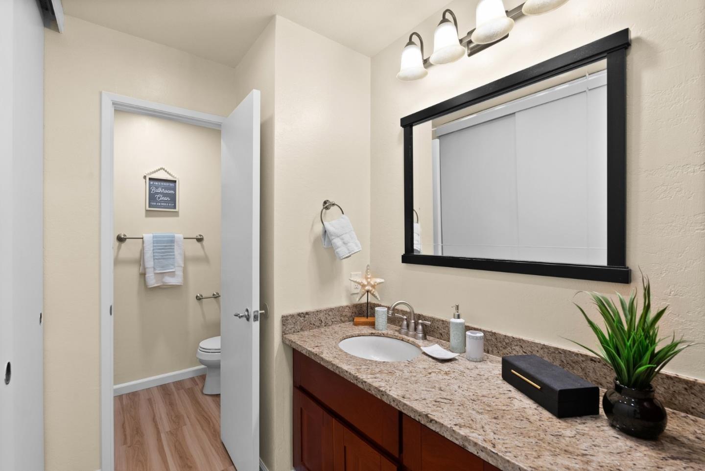 22812 Longdown Road Cupertino, CA 95014 - Photo 30 of 45 a bathroom with a granite countertop sink vanity mirror and toilet