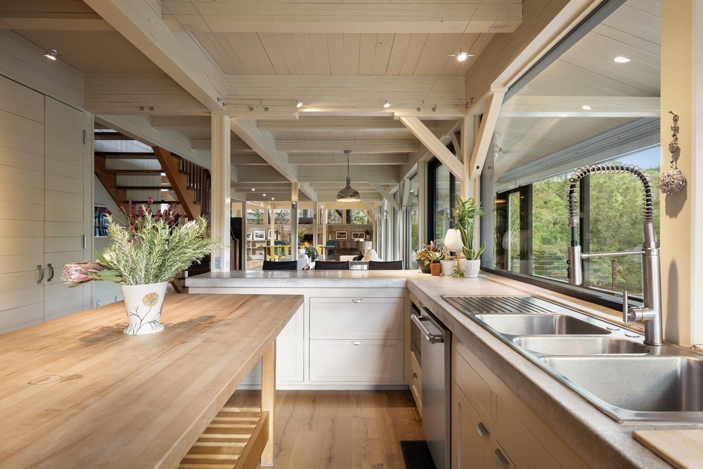 4707 Peace Pipe Path Austin, TX 78746 - Photo 13 of 40 a large white kitchen with a large window and stainless steel appliances