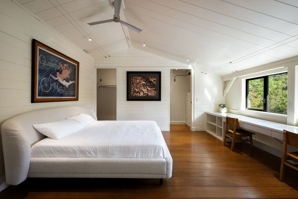 4707 Peace Pipe Path Austin, TX 78746 - Photo 27 of 40 a spacious bedroom with a bed a couch and a window