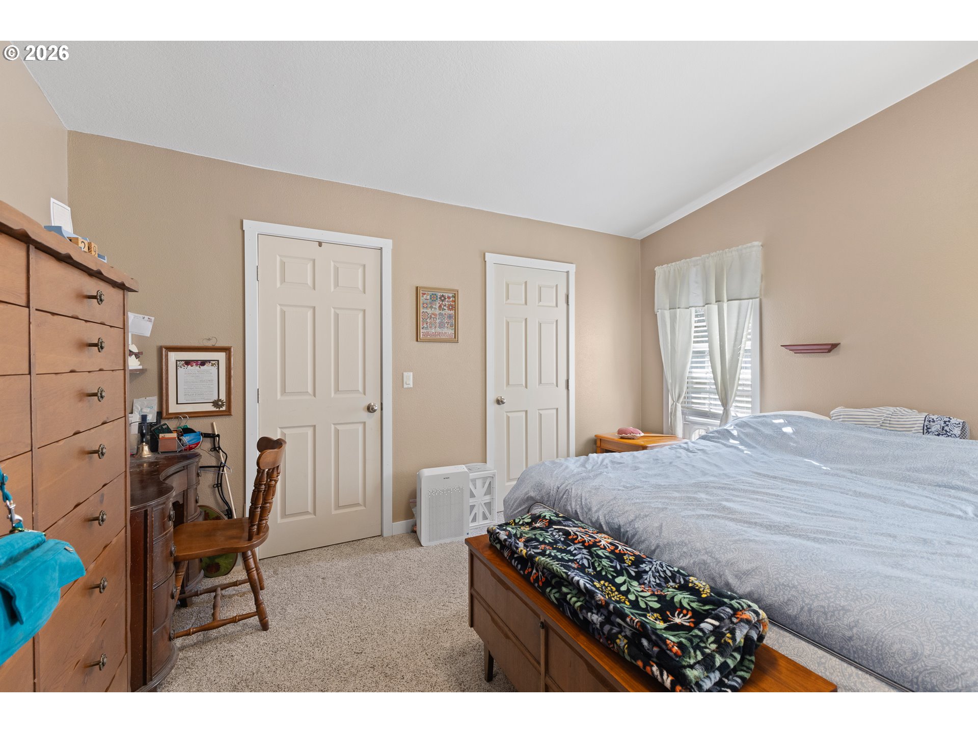 69323 Wildwood Road North Bend, OR 97459 - Photo 13 of 37 a bedroom with a bed a chair and glass door