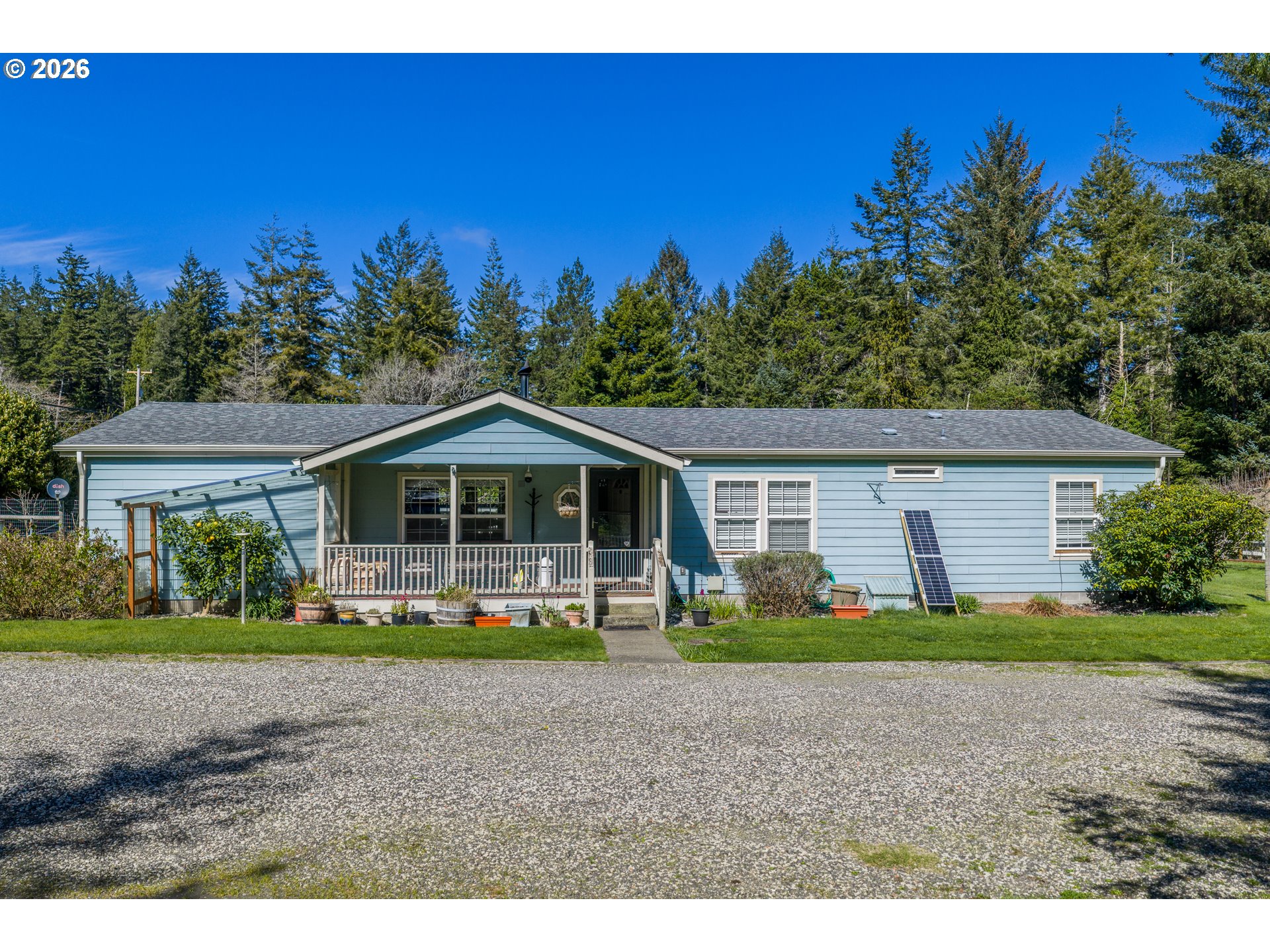 69323 Wildwood Road North Bend, OR 97459 - Photo 2 of 37 a front view of a house with a yard and trees