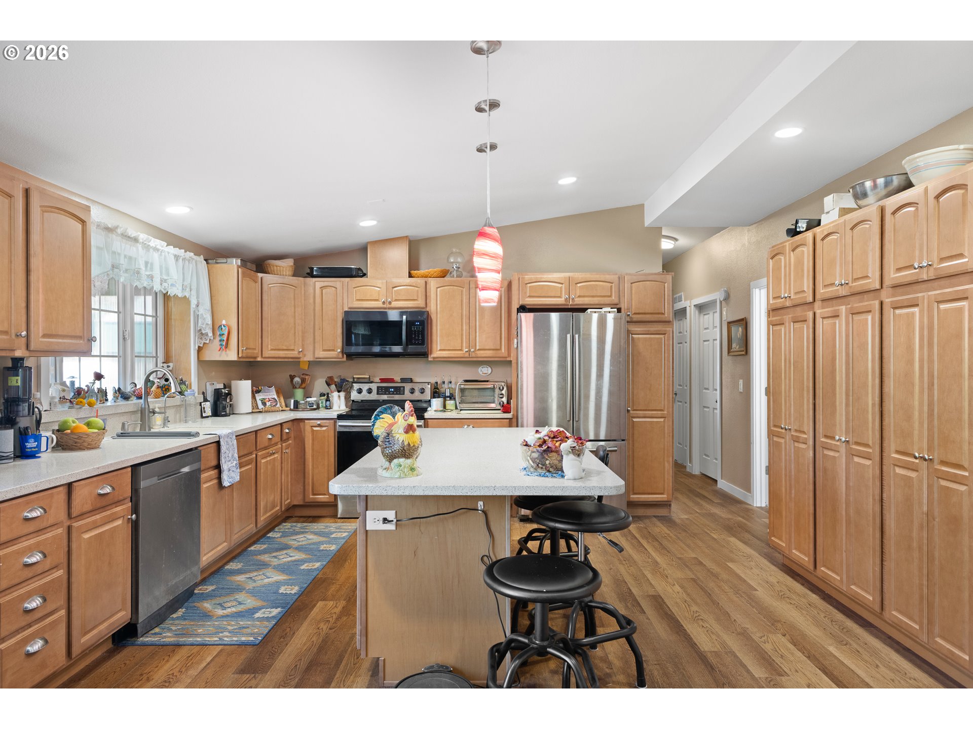 69323 Wildwood Road North Bend, OR 97459 - Photo 8 of 37 a open kitchen with stainless steel appliances kitchen island granite countertop a refrigerator a sink dishwasher and a stove with wooden floor