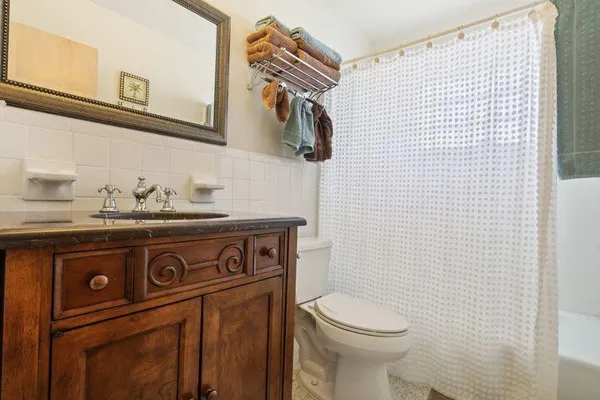 a close view of a sink a toilet and a mirror