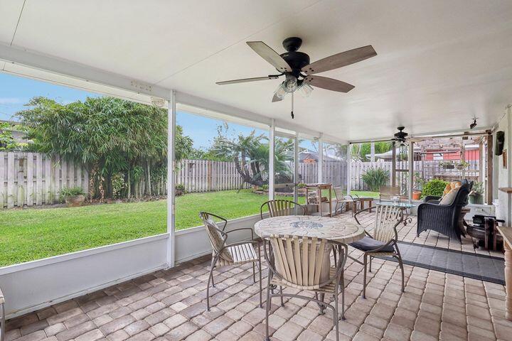 4844 Southeast Pilot Way Stuart, FL 34997 - Photo 28 of 44 a view of a patio with a dining table and chairs with a yard