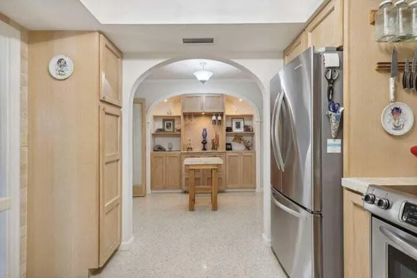a kitchen with a refrigerator and white cabinets