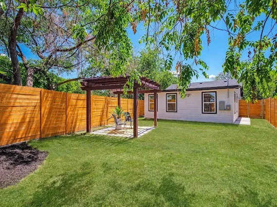 a view of a yard with a house and a large tree