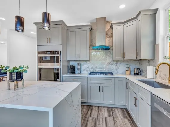 a kitchen with stainless steel appliances granite countertop a refrigerator sink and white cabinets