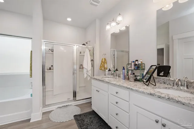 a bathroom with double vanity sinks and a shower