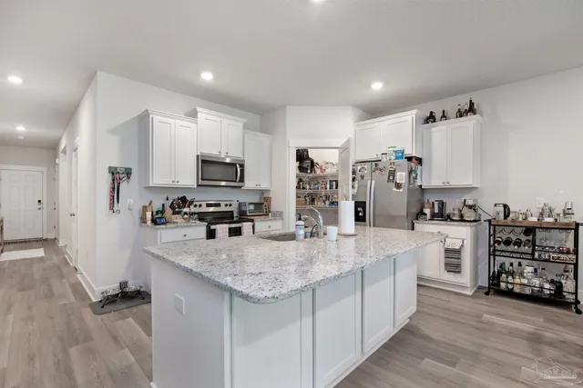 a large kitchen with kitchen island a sink appliances and cabinets