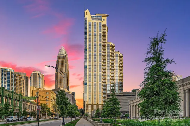 a front view of a multi story building with yard