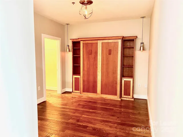 a view of a room with wooden floor and brick walls