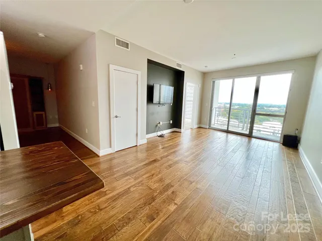 a view of an empty room and wooden floor