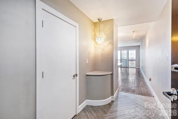 a kitchen with kitchen island granite countertop a sink a stove a refrigerator and white cabinets with wooden floor