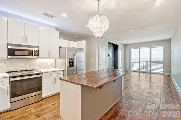 a large kitchen with stainless steel appliances granite countertop a stove and cabinets