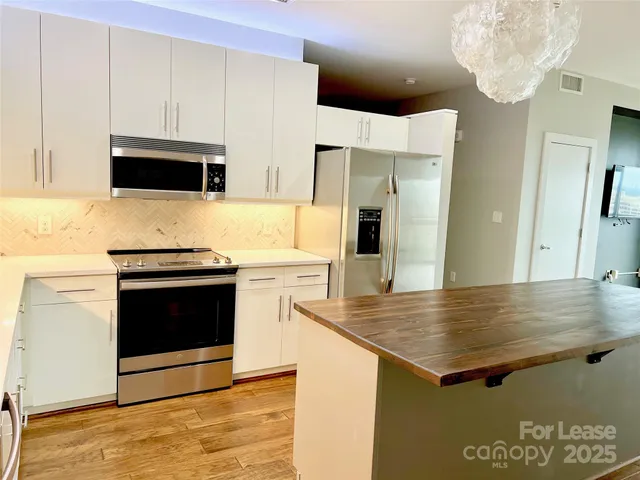 a kitchen with stainless steel appliances a stove microwave and cabinets