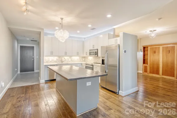 a kitchen with stainless steel appliances granite countertop a refrigerator and a sink