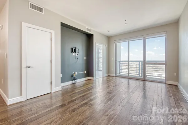 an empty room with wooden floor and windows