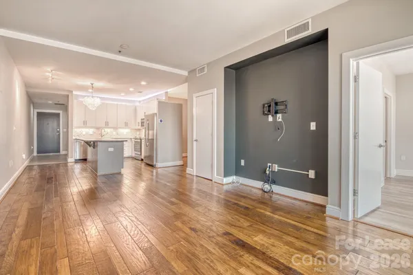 a view of a hallway with wooden floor and a living room
