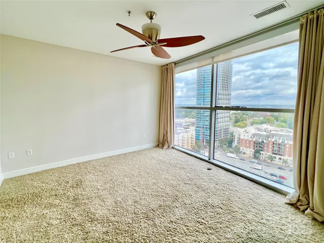 a view of an empty room and window ceiling fan