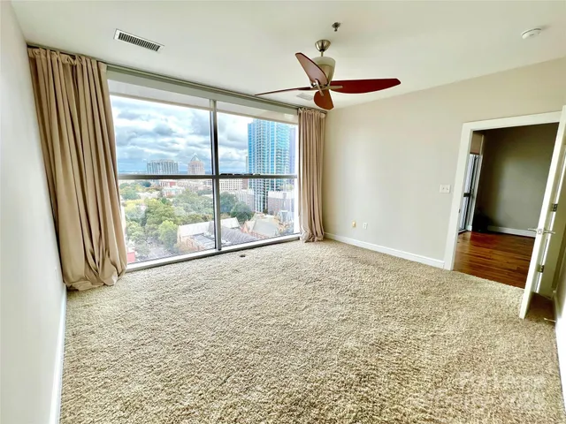 an empty room with a fireplace and a large window